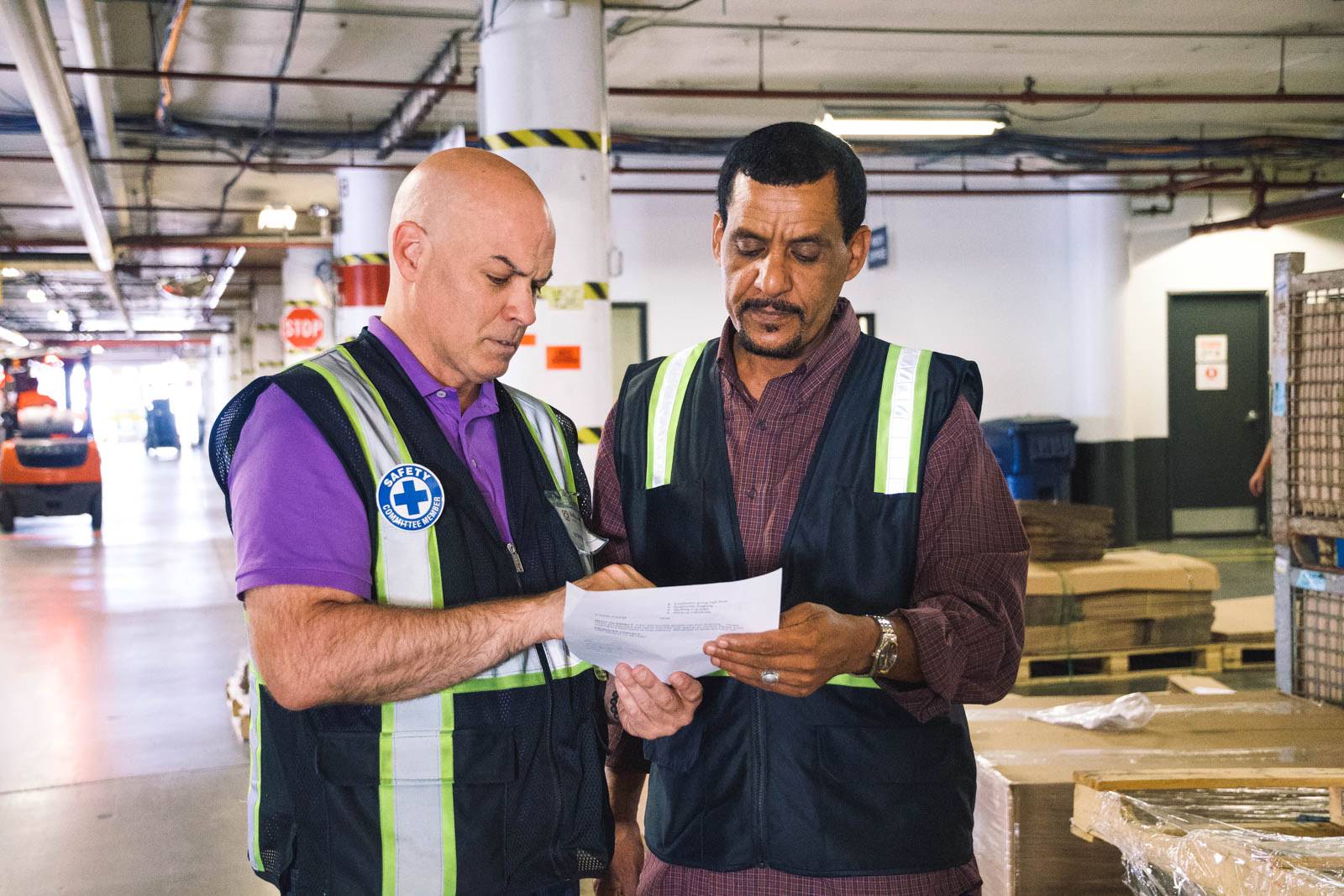 Two warehouse employees review an order form together