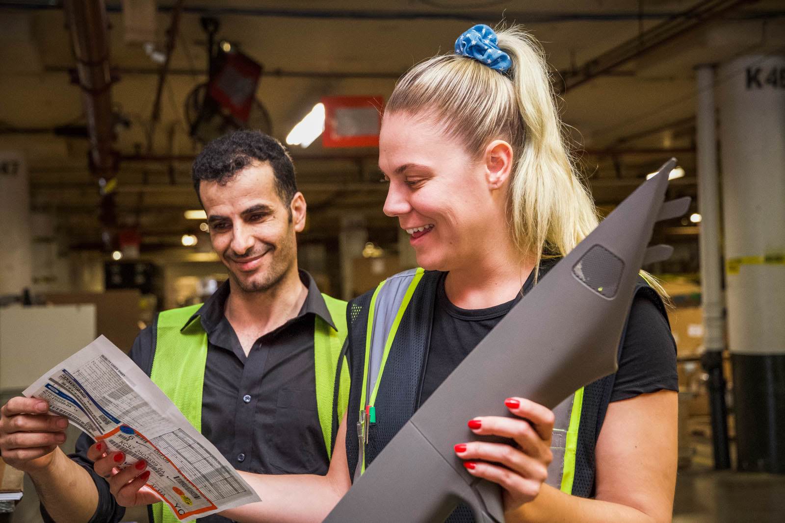Two warehouse employees review an order form together